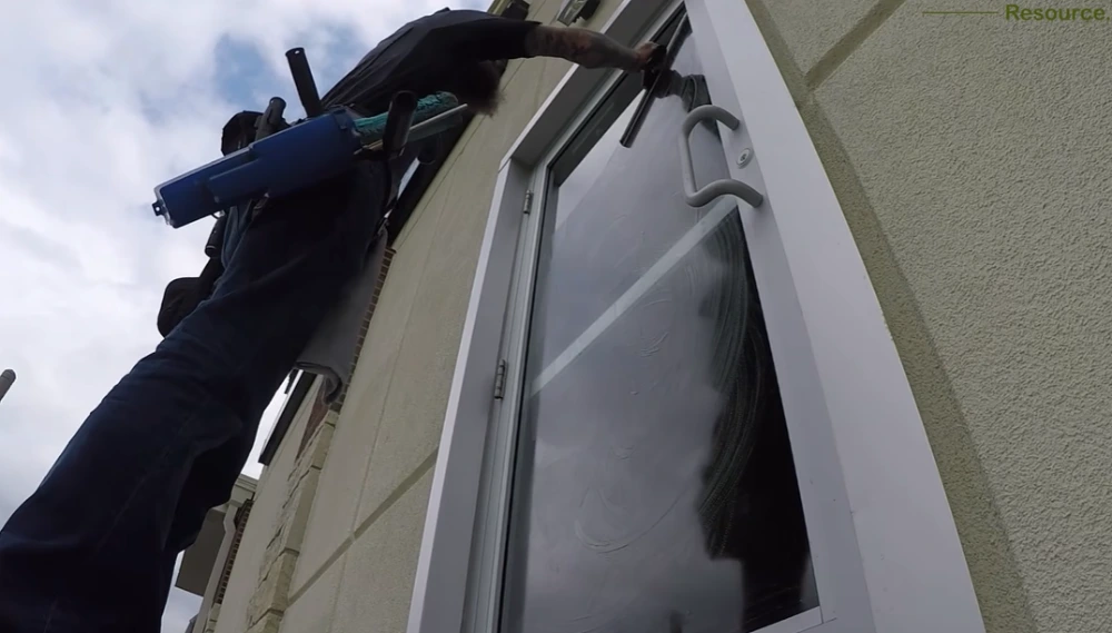 Professional window cleaner San Clemente CA working on two-story home exterior